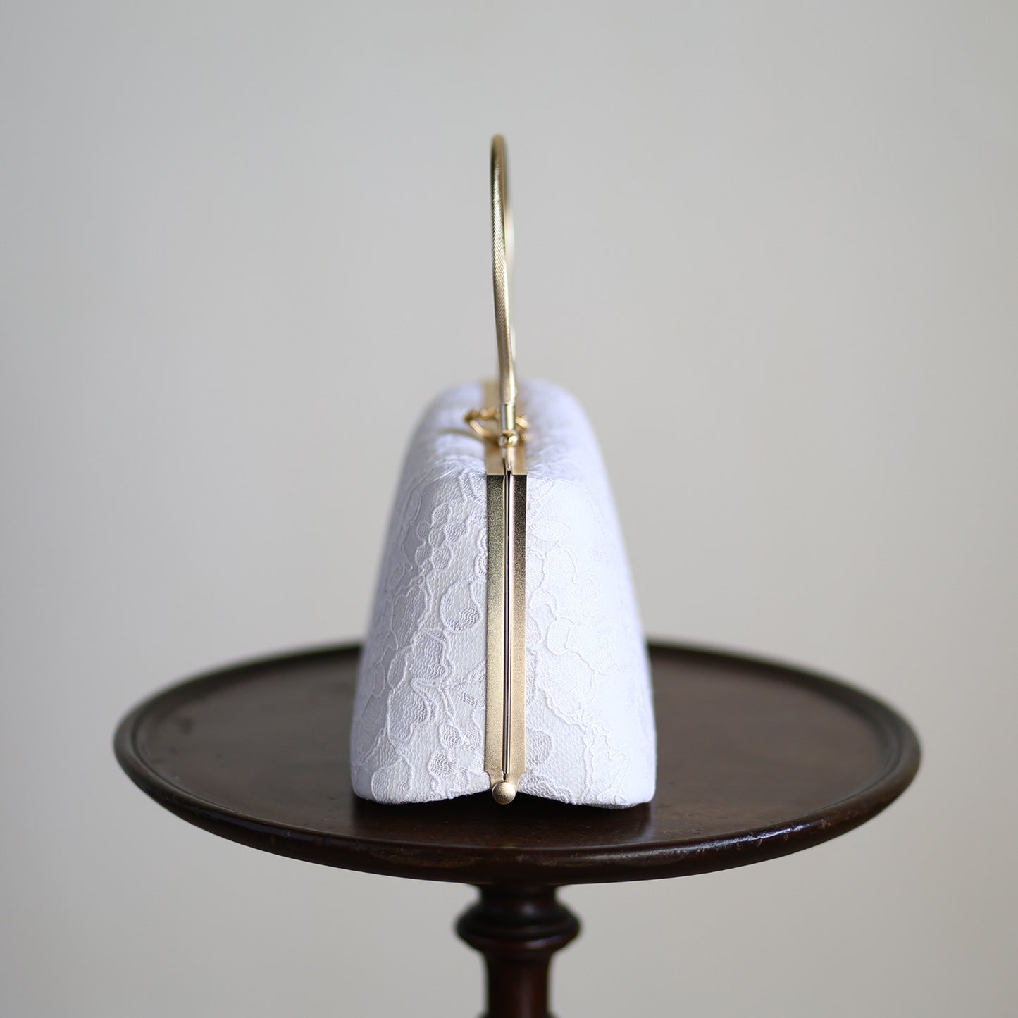 Side view of a white lace handbag